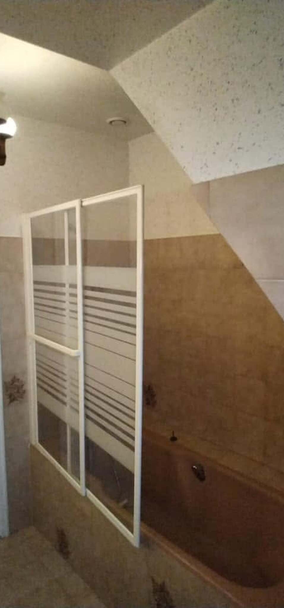 La salle de bain avant travaux : baignoire avec pare-bain